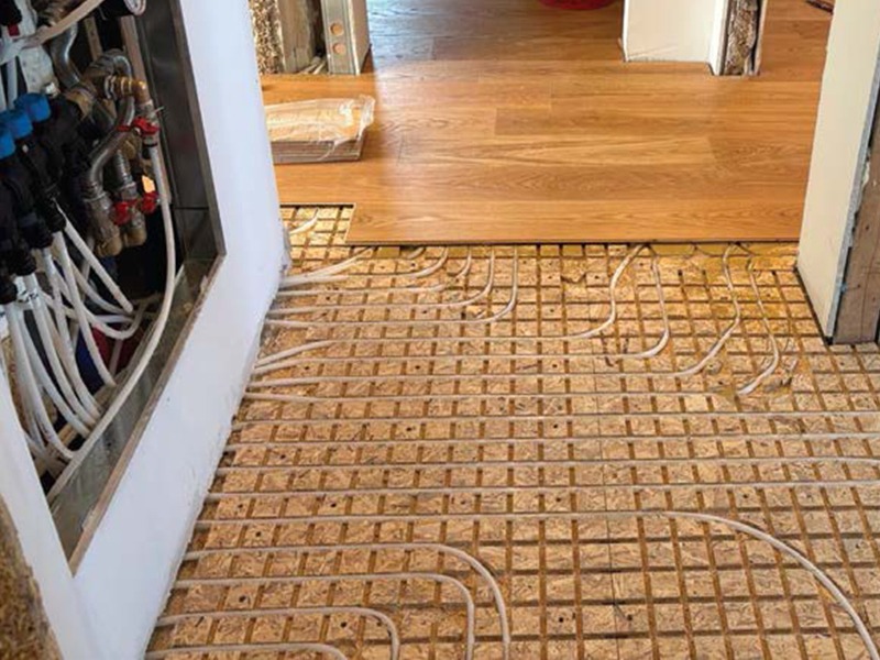 Installazione a secco del pannello radiante Easy D-Ray con vista del collettore in corridoio